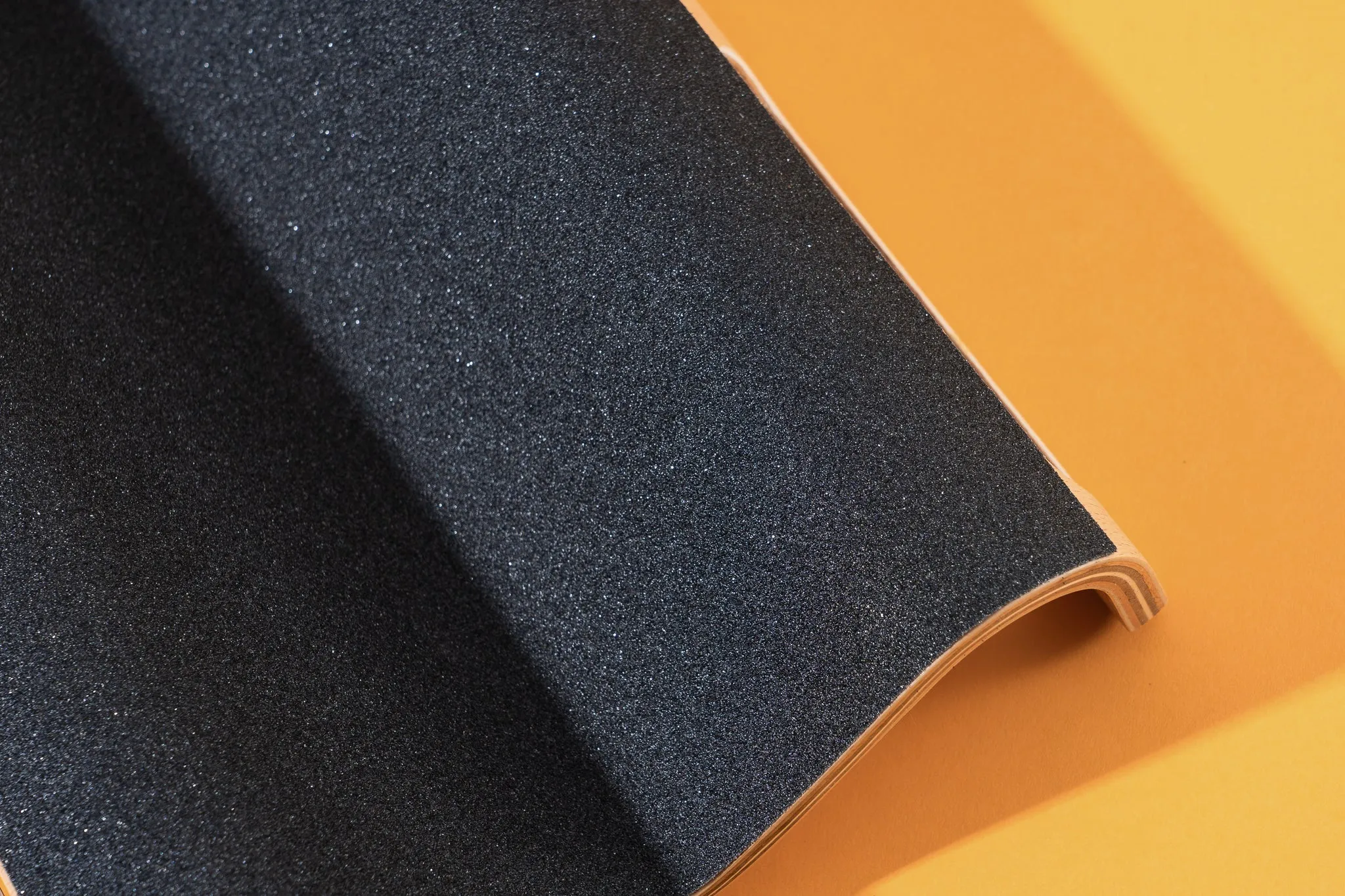 A closeup of the black sandpaper layer on the LovIntry M-Shaped Dog Scratch Pad for Nails.