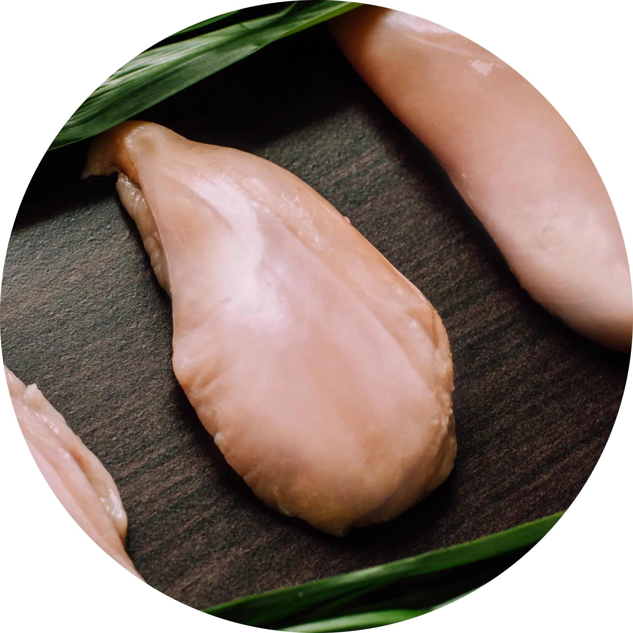 Real chicken breast pieces laid out on a white surface, highlighting the primary protein source