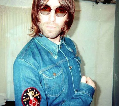 Oasis performing live on stage during their peak years in the 1990s British music scene