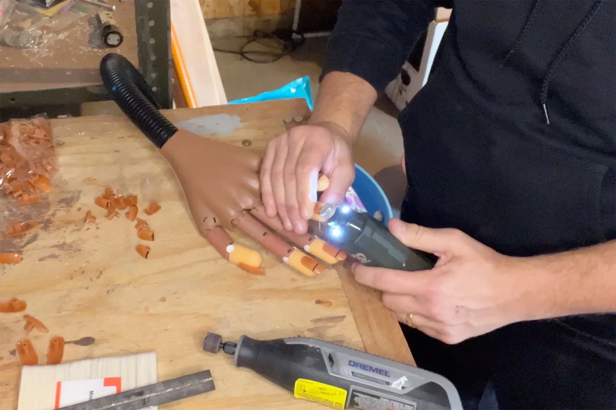 A person using a Casfuy nail grinder to file the nails of a practice hand.