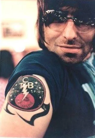 Liam Gallagher photographed showing his arm with the Elvis TCB lightning bolt tattoo