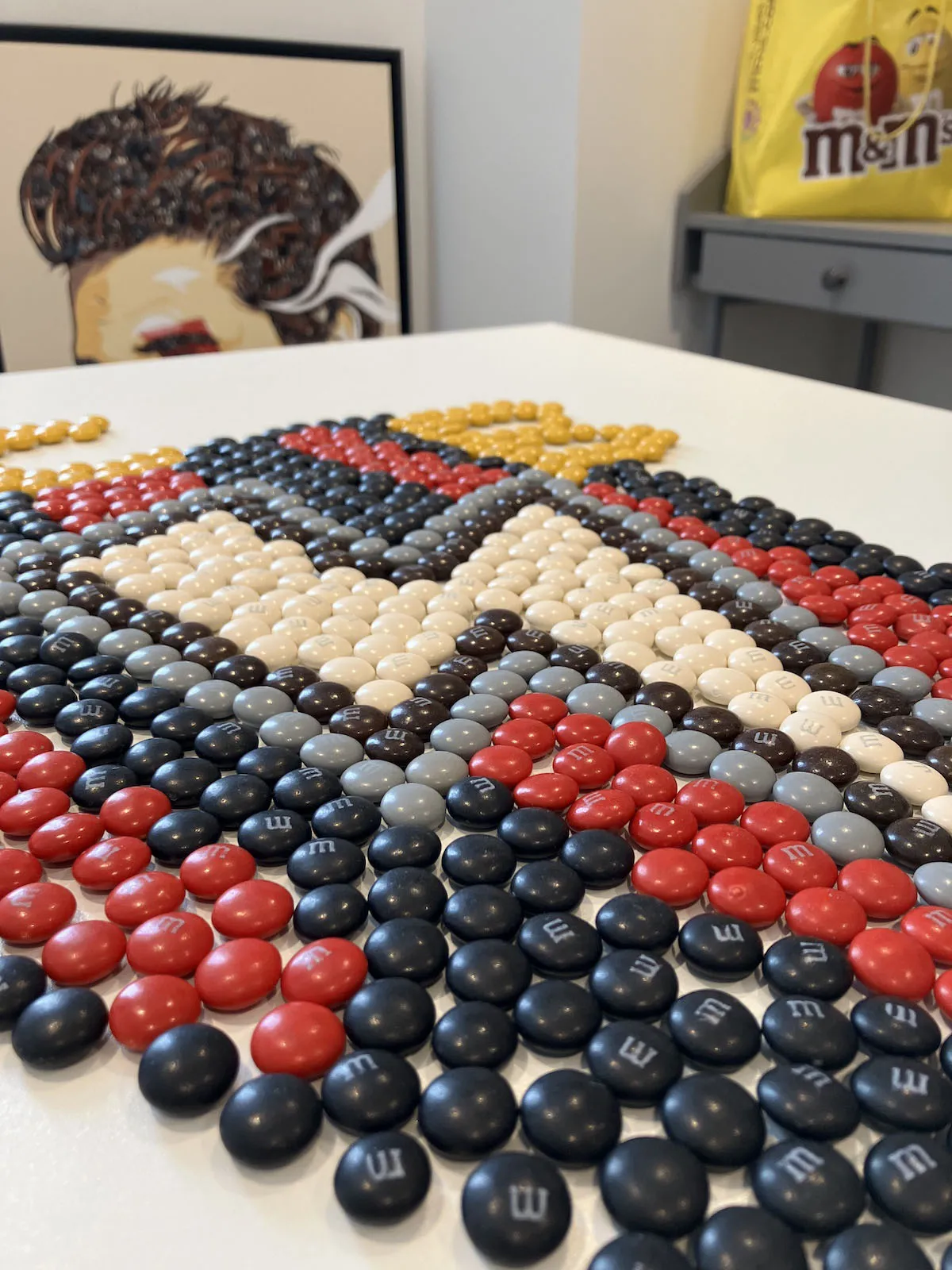 Close-up view of the M&M chocolate TCB artwork showing the individual sweets arranged to form the lightning bolt symbol