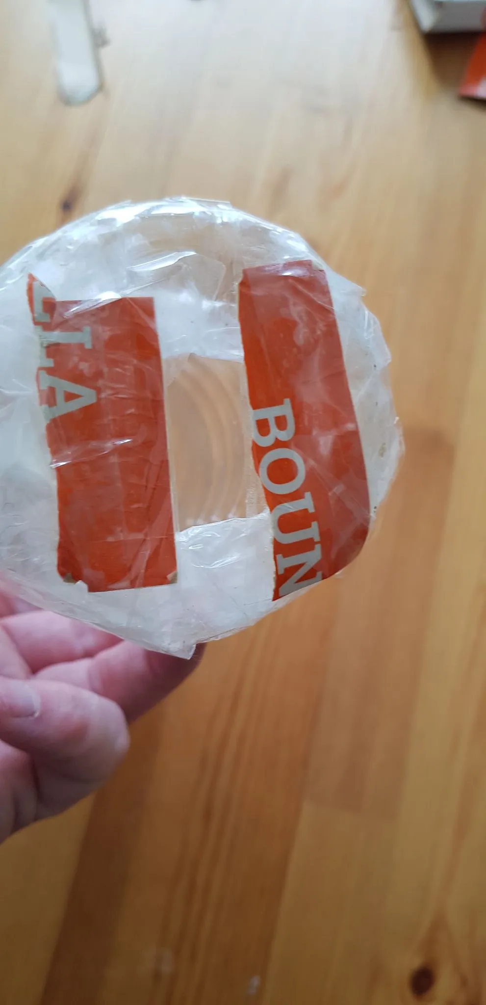 The bottom of the bottle with a hole cut in the cardboard base, ready for treats.