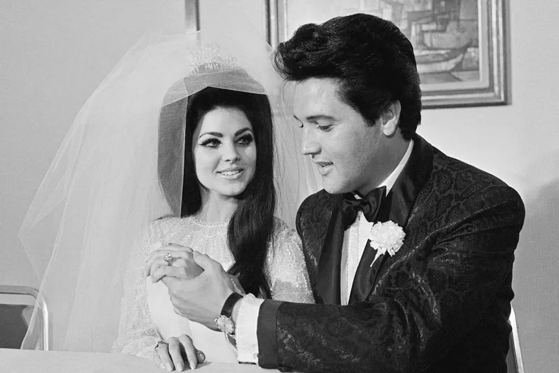 Elvis and Priscilla Presley on their wedding day, both sporting dark hair.