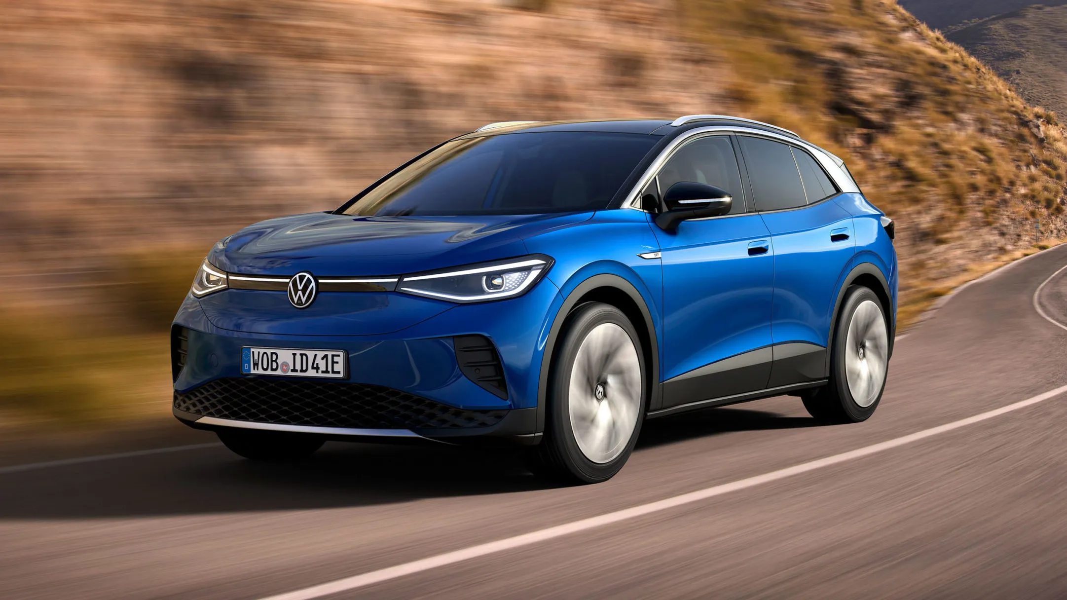 Volkswagen ID.4 in blue driving on an open road, showcasing the front exterior design language shared with the upcoming ID.8