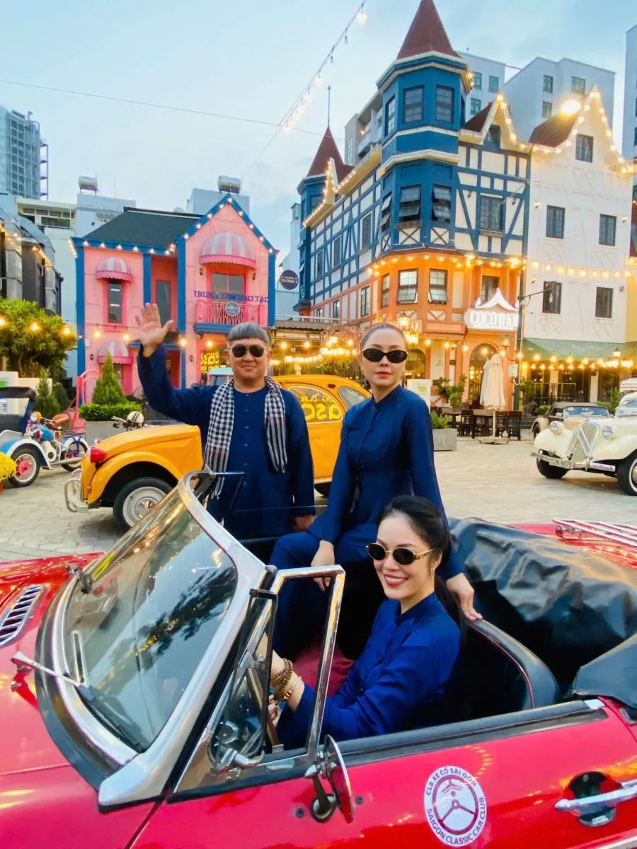 Mr. Huynh Minh Hiep taking a commemorative photo with local actresses at the classic car event