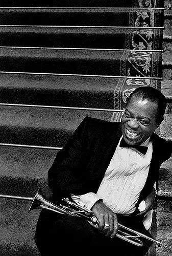 Louis Armstrong performing with his trumpet in a scene from the movie