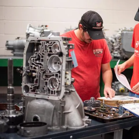 Automotive students working in a hands-on engine lab environment