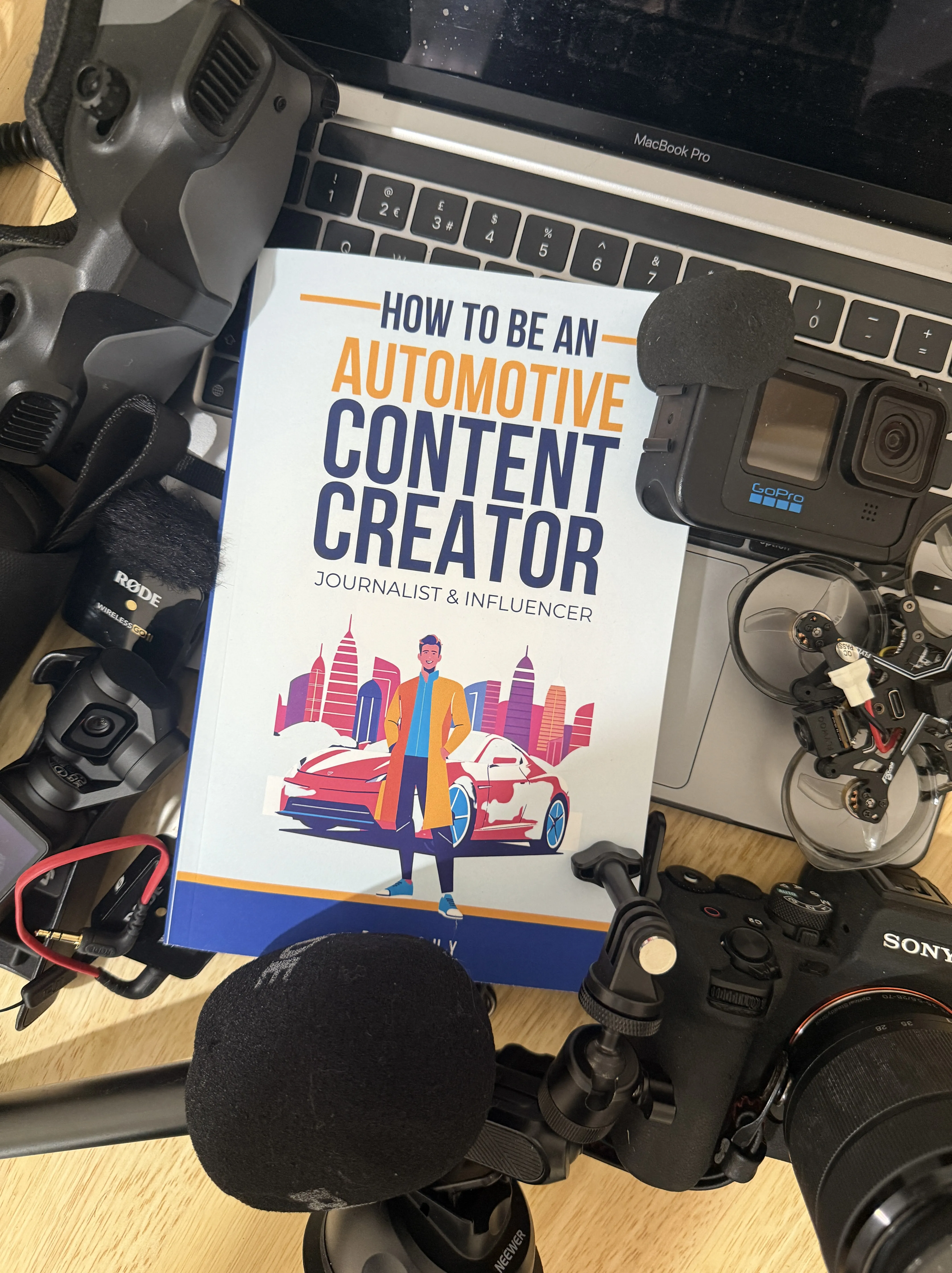 Author holding books for automotive content creation and storytelling