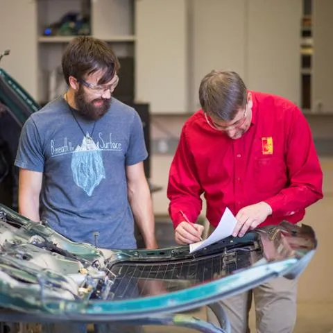 Automotive lab students practicing mechanical repair techniques on training engines