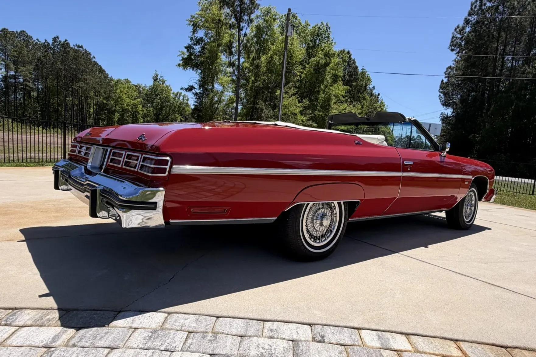 Red 1975 Chevrolet Caprice Classic convertible front view showing chrome grille and quad headlights