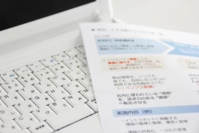 Laptop, printed documents, and workspace materials prepared for spreadsheet tasks