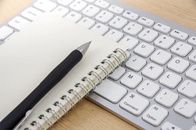 Hands operating a laptop keyboard while working with Excel shortcuts