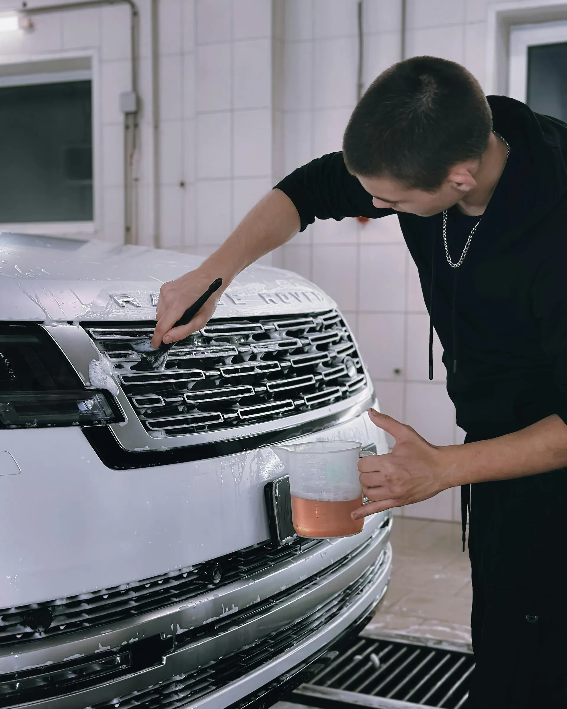 Certified technician performing detailed car repairs in a professional auto body shop
