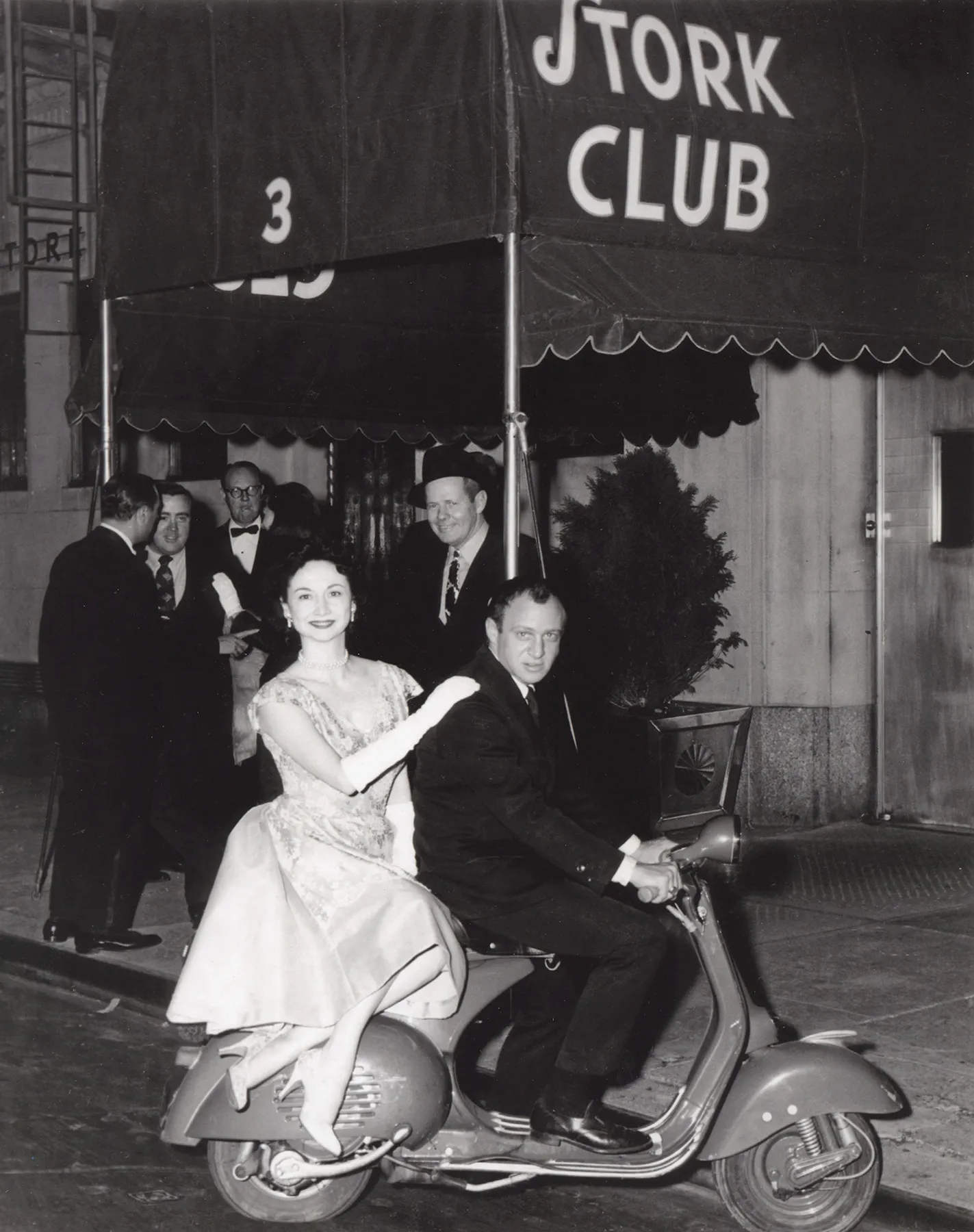 Dorothy Kilgallen and a friend on a scooter outside the Stork Club