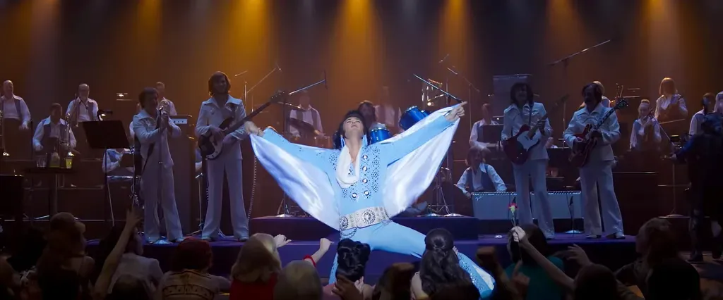 Elvis Presley performing on stage in an elaborate jumpsuit during a high-energy concert scene