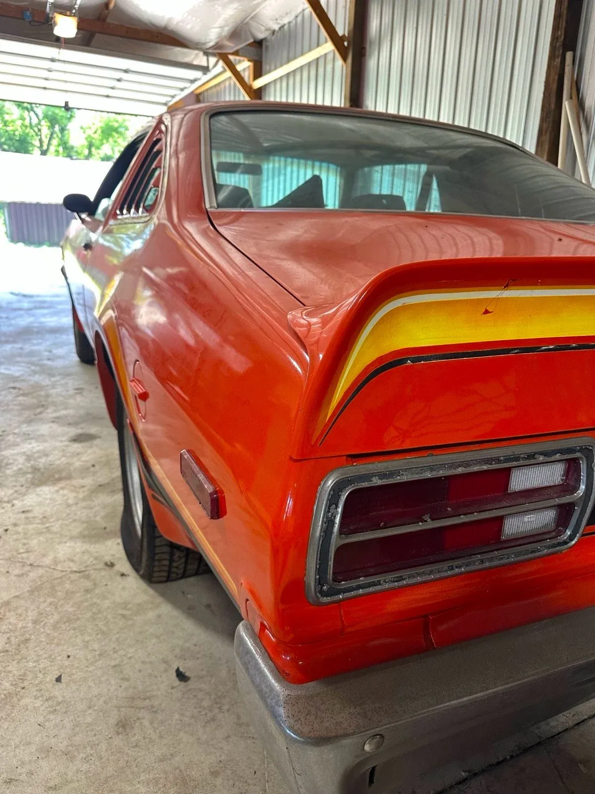 Rear quarter view of abandoned 1976 Plymouth Volare Road Runner barn find showing aged paint and classic muscle styling cues