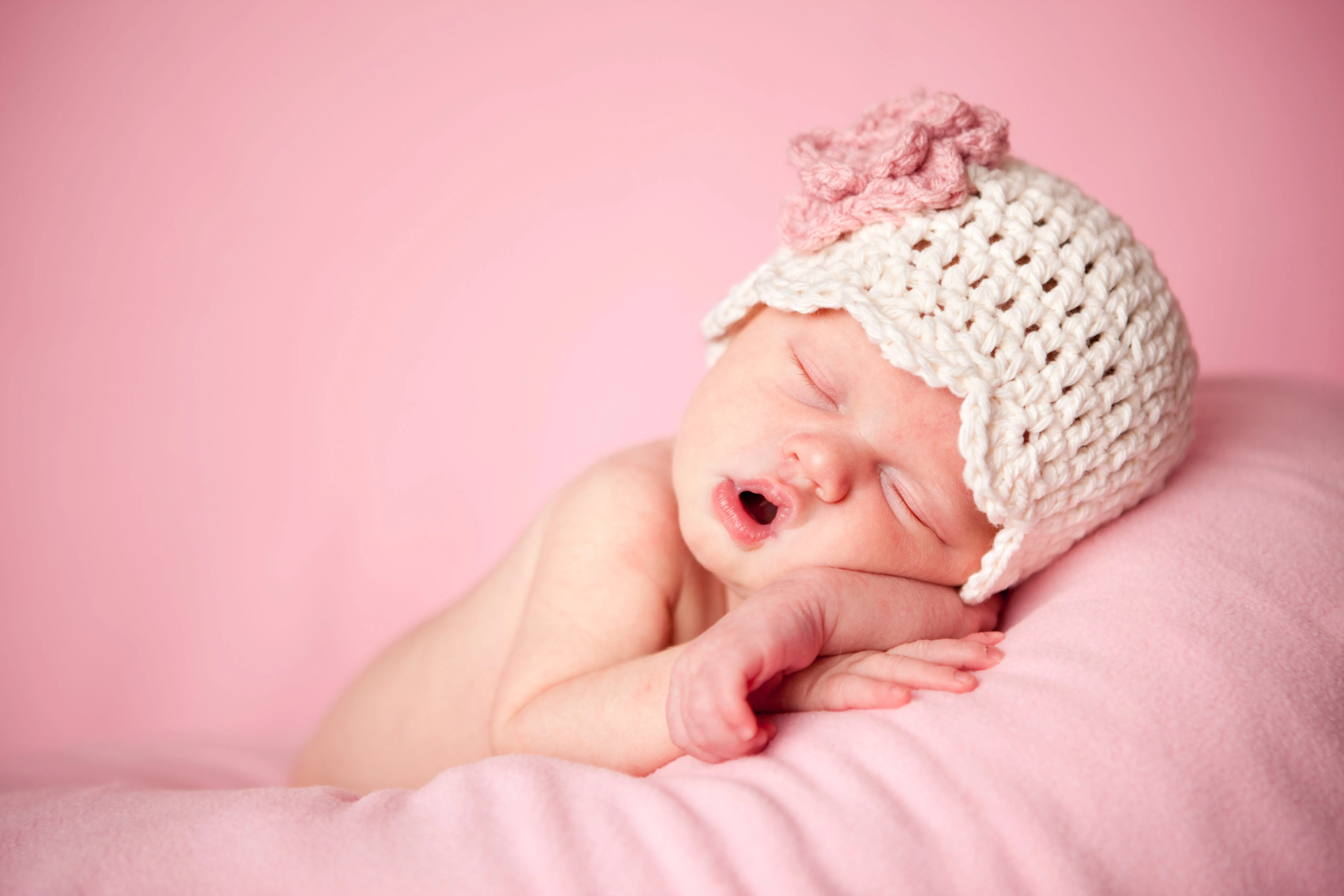 Sleeping newborn baby girl wearing a knitted hat representing peaceful baby nickname inspiration