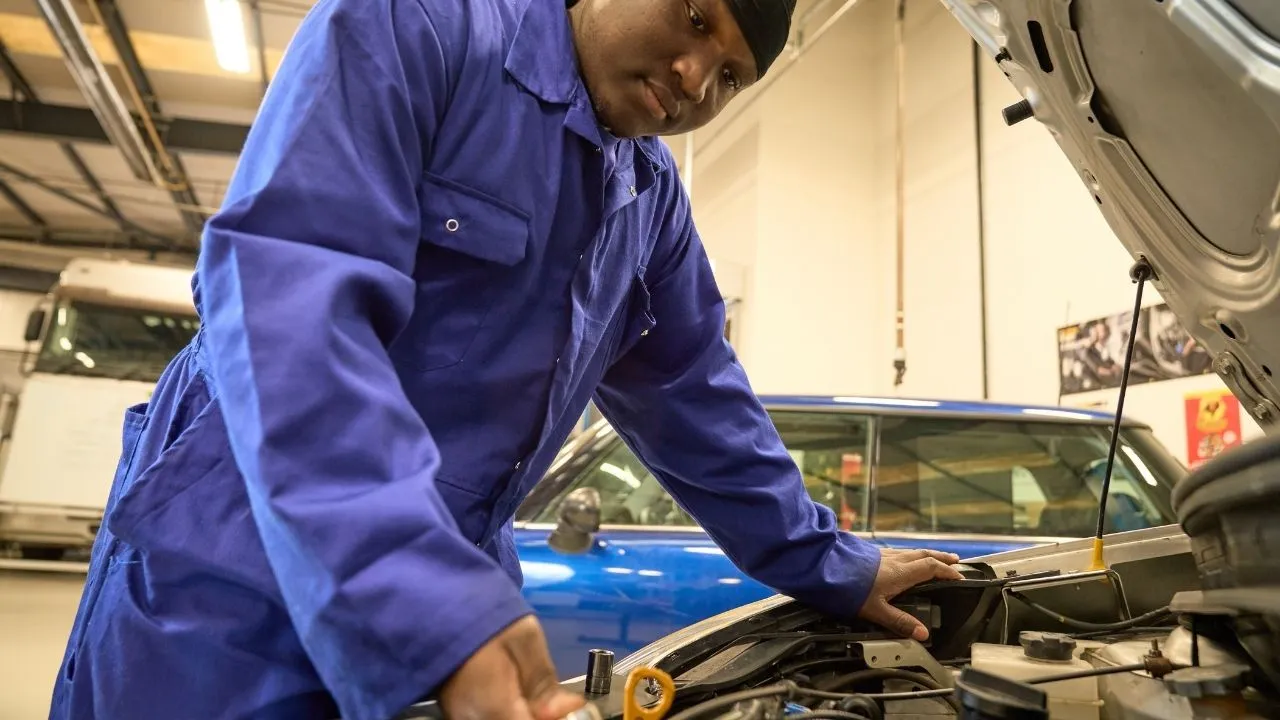 Automotive workshop showing diagnostic equipment connected to a vehicle during technical training