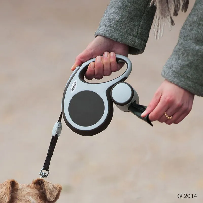 Person holding a retractable lead with an attached waste bag dispenser, demonstrating easy access to poop bags during a dog walk