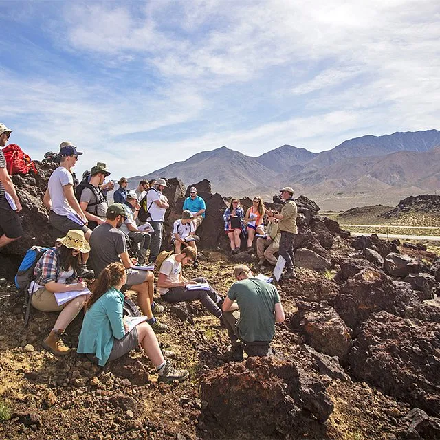 Geology students conducting field research in a desert environment