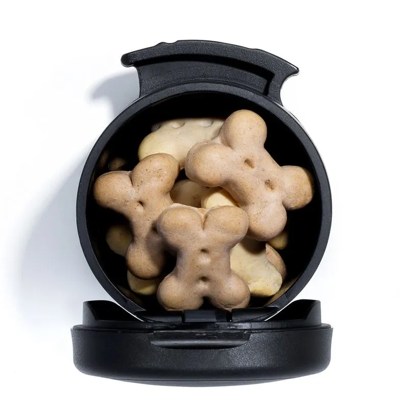 Opened black container holding bone-shaped dog treats, showing the storage capacity and easy treat access of the Multi Box