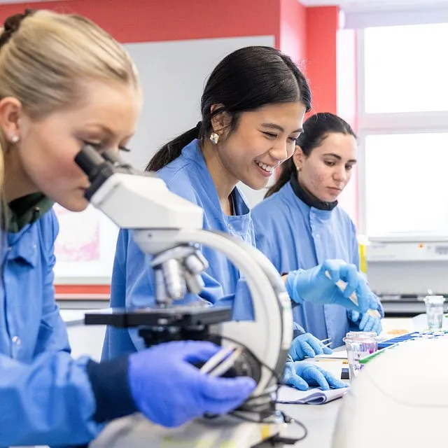 Biomedical science students working in a laboratory environment with modern research equipment