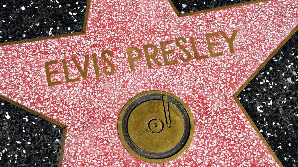 Black-and-white portrait of Elvis Presley capturing his early rise to fame and cultural impact
