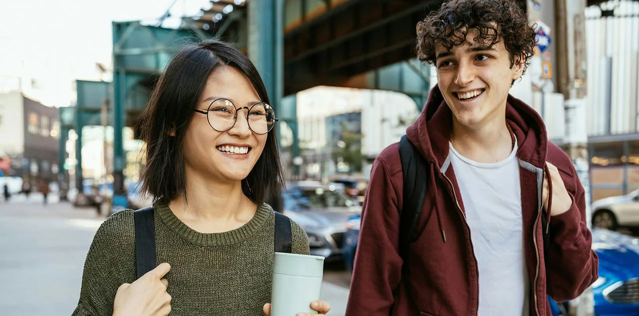 Friends walking down the street laughing together, representing in-person connection