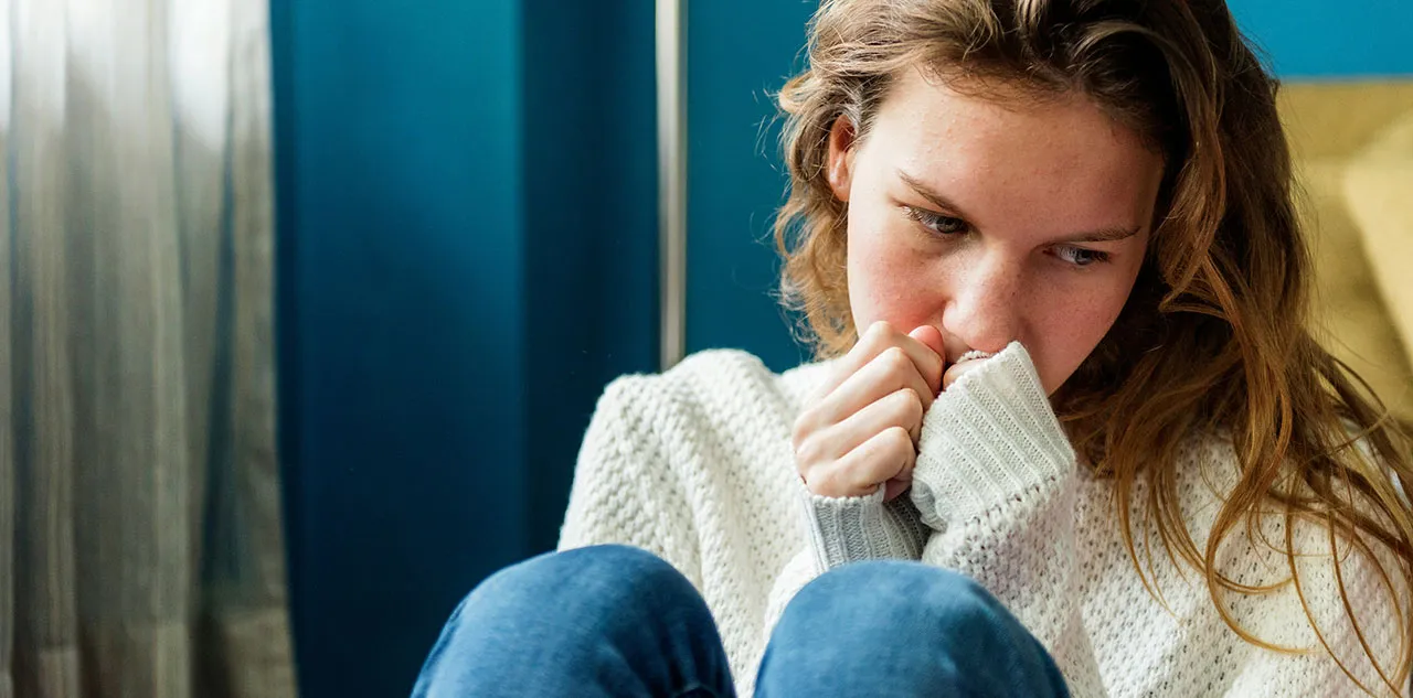Teen feeling lonely while using a phone, reflecting on online interactions