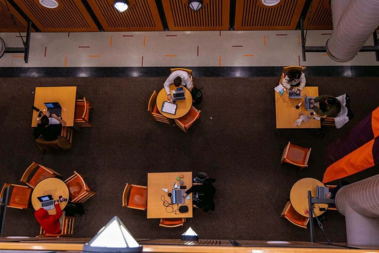 Overhead view of students collaborating at tables during finals week in Torgersen Hall at Virginia Tech