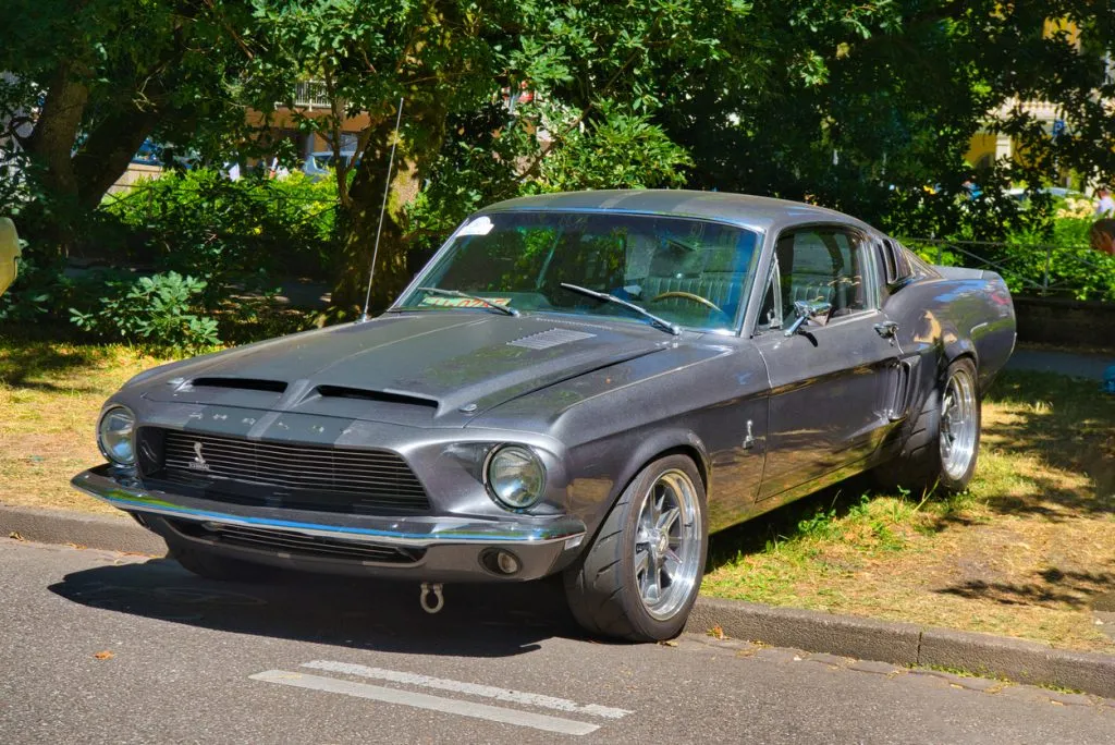 1965 Ford Mustang GT cruising on suburban road
