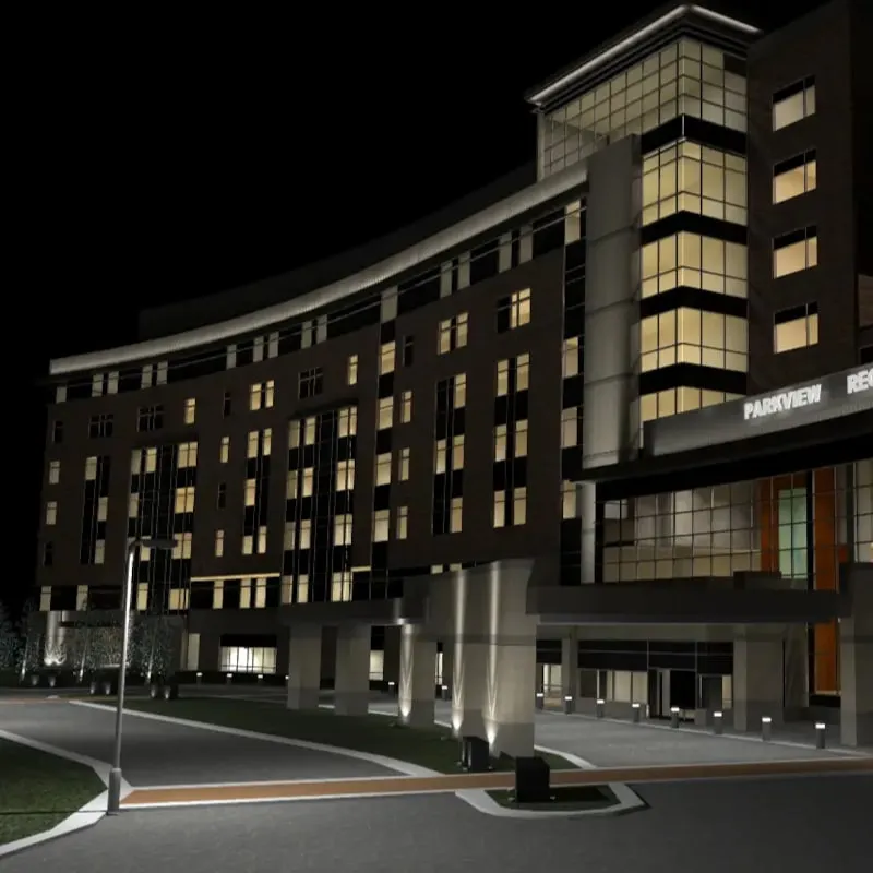 A modern multi-story building is illuminated at night with many windows lit; Photometric Calculation ensures optimal lighting, while Parkview is visible on a sign near the entrance.