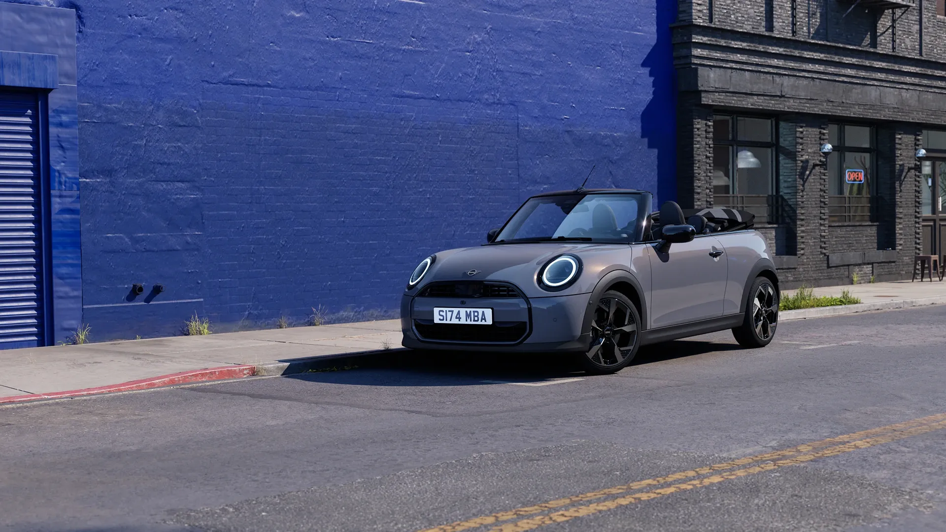MINI Cooper Convertible with soft-top roof open on a scenic road
