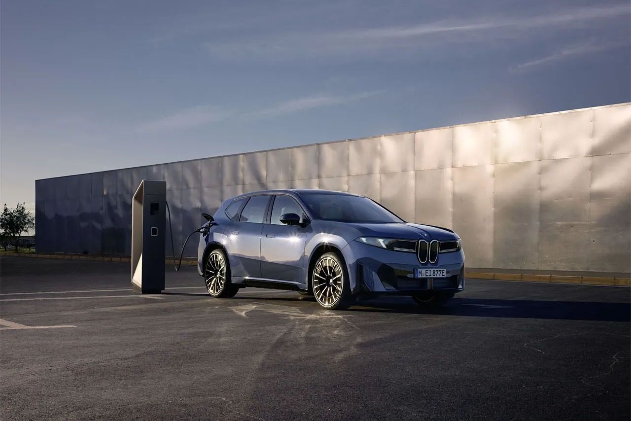 BMW i3 electric SUV in an urban setting with natural elements, highlighting compact EV design
