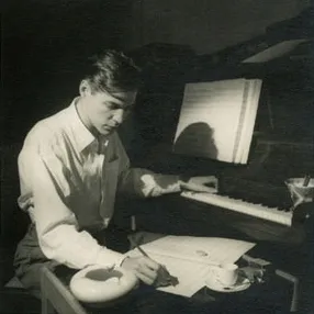 A grand piano illuminated on stage, symbolizing the classic oldies music era and the sophisticated artistry of Frank Sinatra