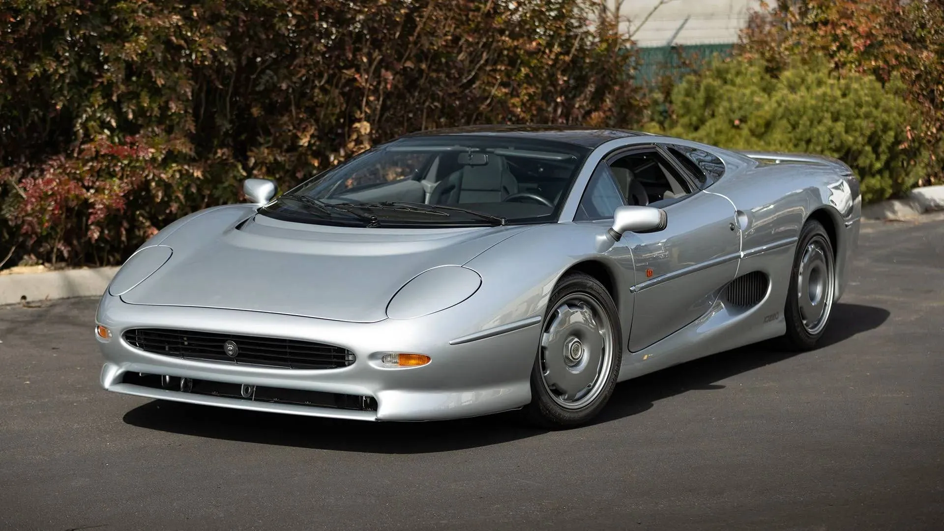 Jaguar XJ220 parked in outdoor setting showing rear design and racing-inspired stance