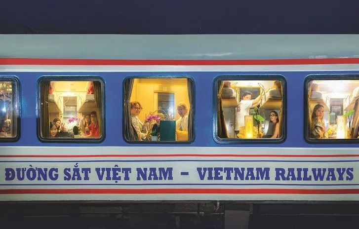Passengers enjoying Vietnam train travel on one of the most scenic trains in Vietnam, the Reunification Express sleeper cabin