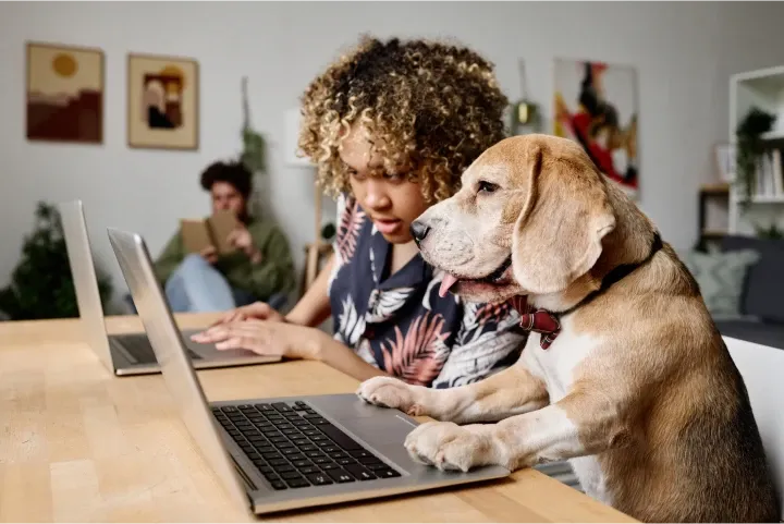 Woman working alongside her dog at a home office setup