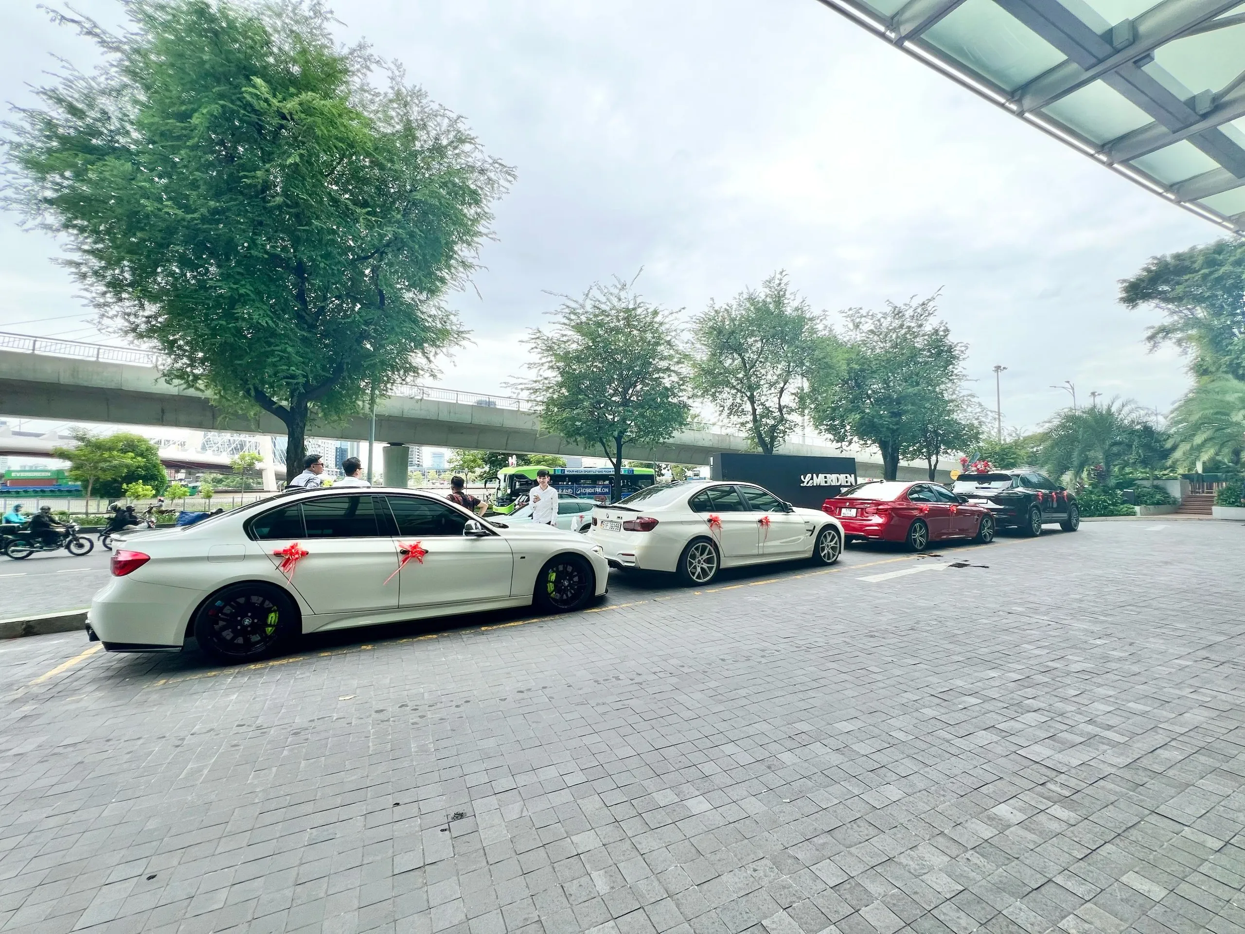 Wedding guests and bridal party photographed alongside luxury supercars