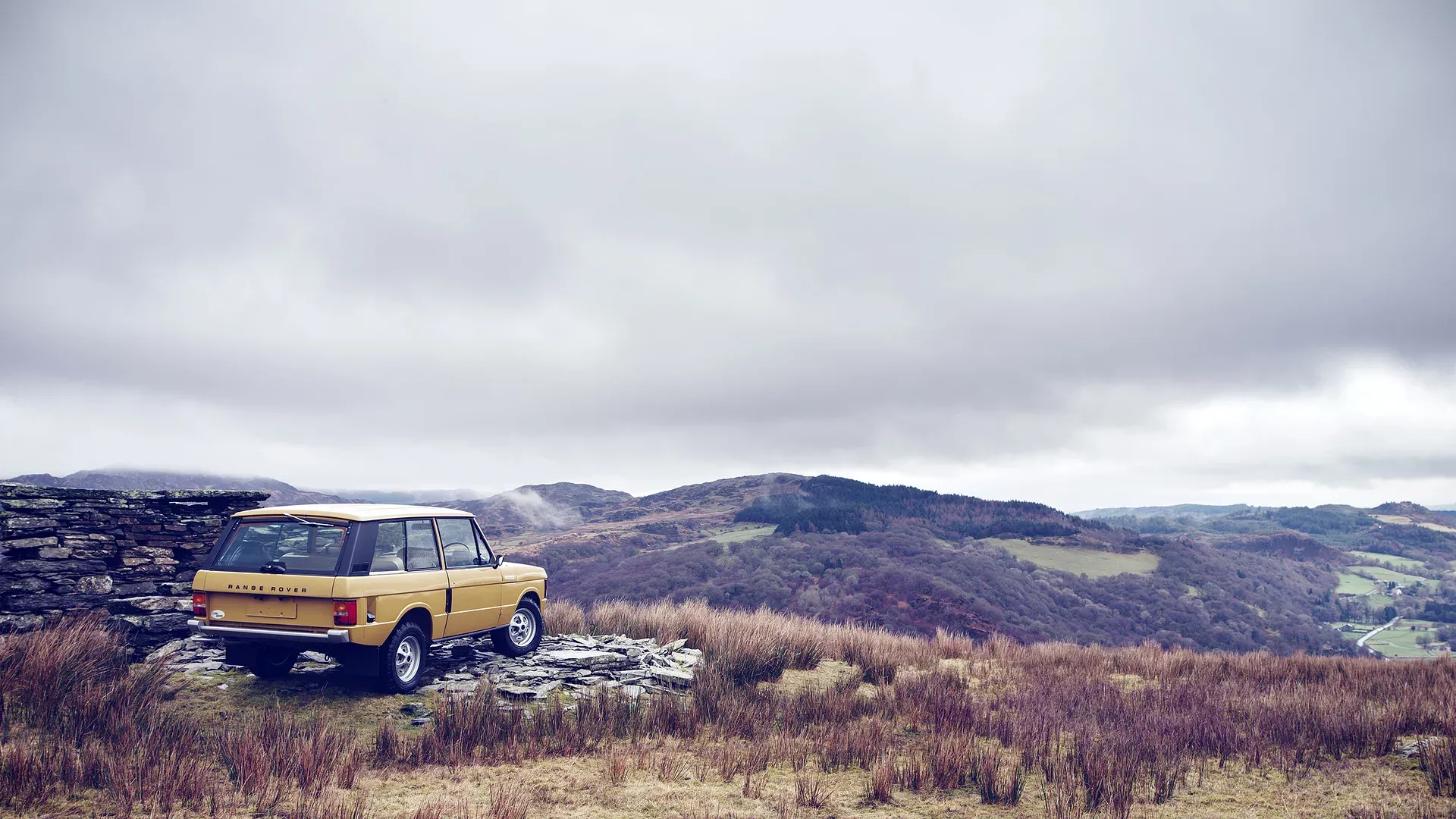 Range Rover classic parked on a hilltop overlooking open countryside