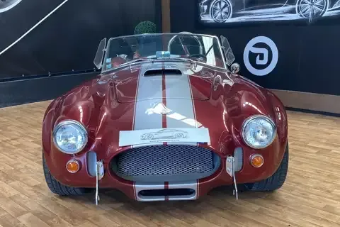 AC Cobra 427 Mk III sports car finished in silver with dual racing stripes