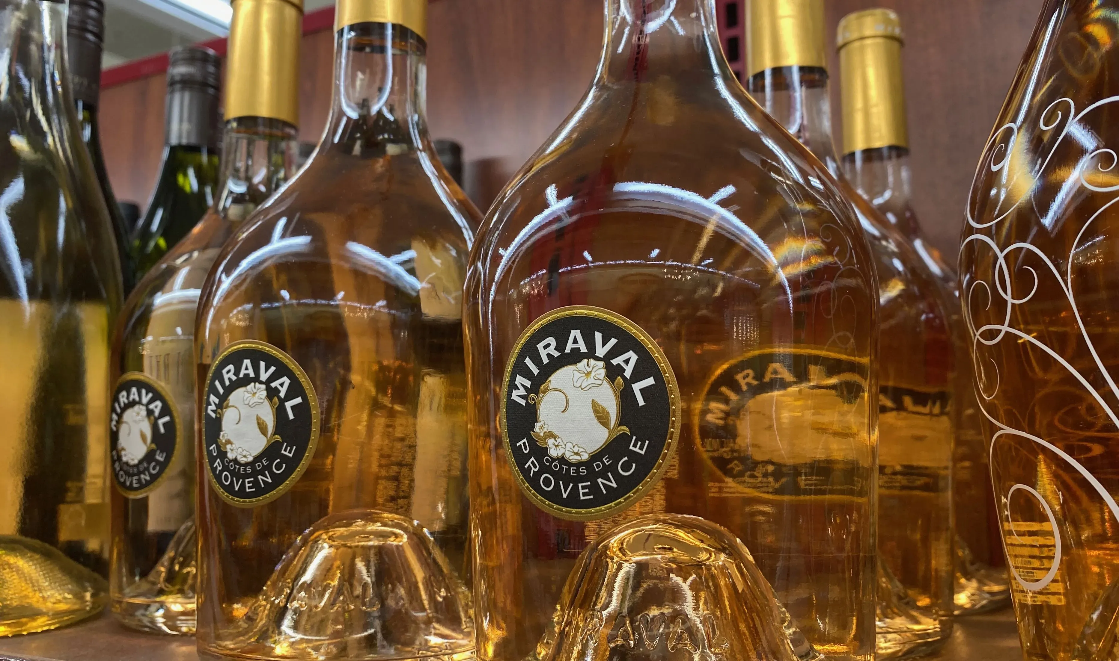 Bottles of Chateau Miraval Cotes de Provence rosé wine on a shelf.