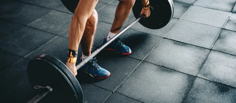 a person preparing to deadlift a loaded barbell using a wide grip