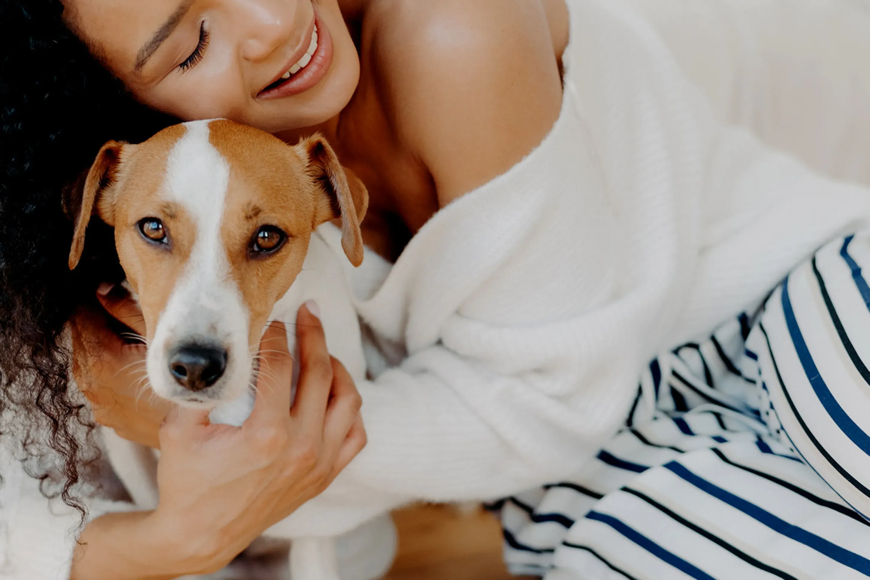 A woman says goodbye to her dog, who looks sad by the door