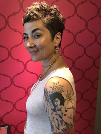 Christina Holgate’s Elvis concert portrait tattoo blending 1969-era stage imagery with colorful jumpsuit-inspired patterns
