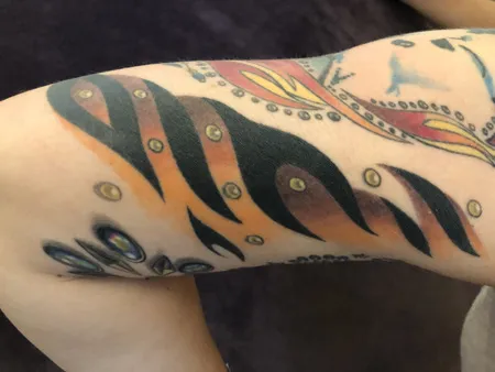 Final stage of Elvis-themed tattoo sleeve showcasing completed composition with rich color and detailed jumpsuit patterns