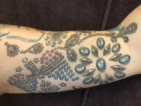 Ongoing tattoo sleeve development showing additional Elvis jumpsuit embellishments added during later sessions