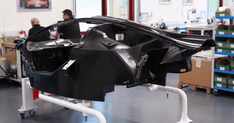 High-performance supercar with aggressive aerodynamic styling and large rear wing parked in a modern showroom