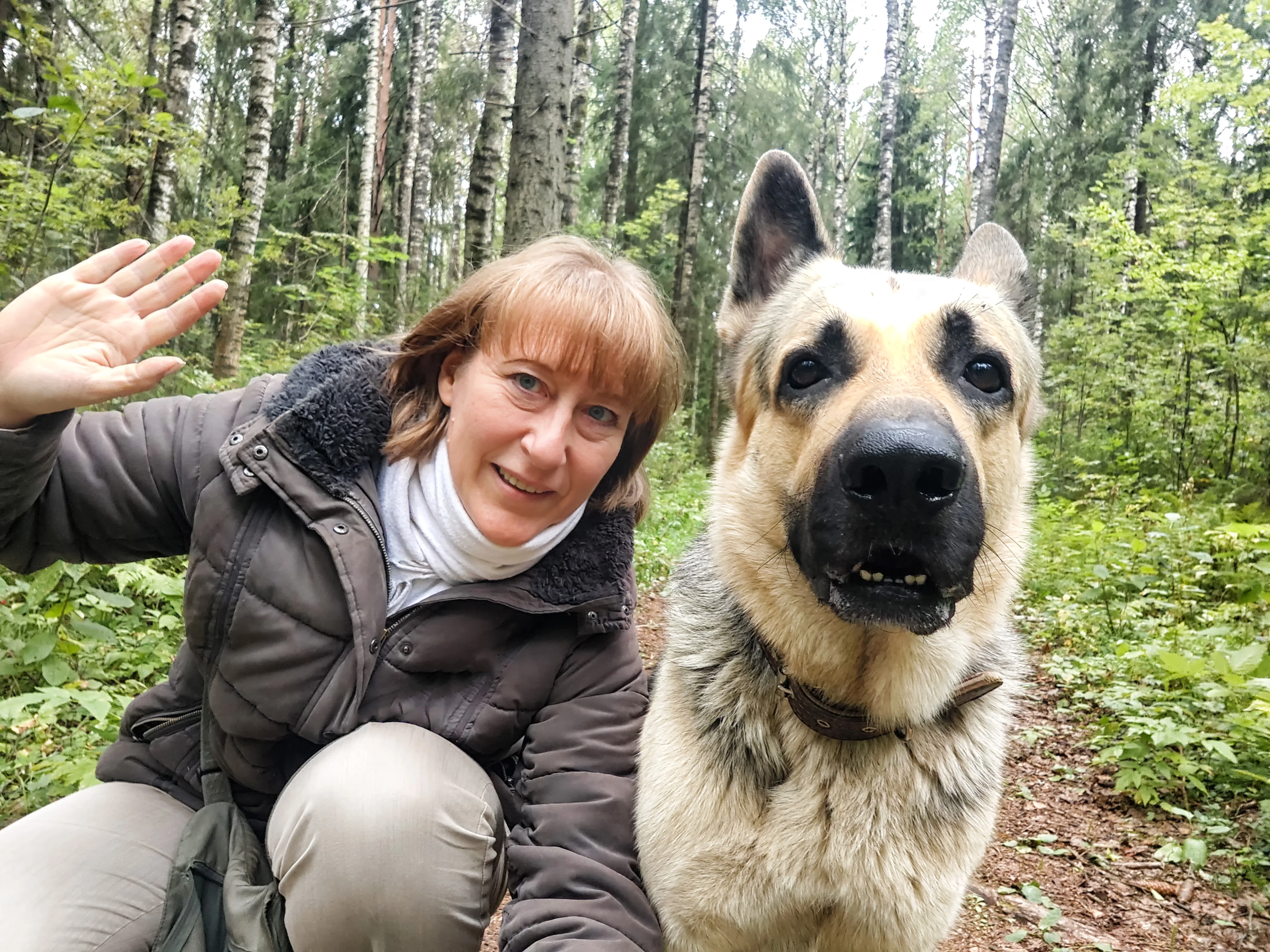 Woman walking a dog outdoors on a leash